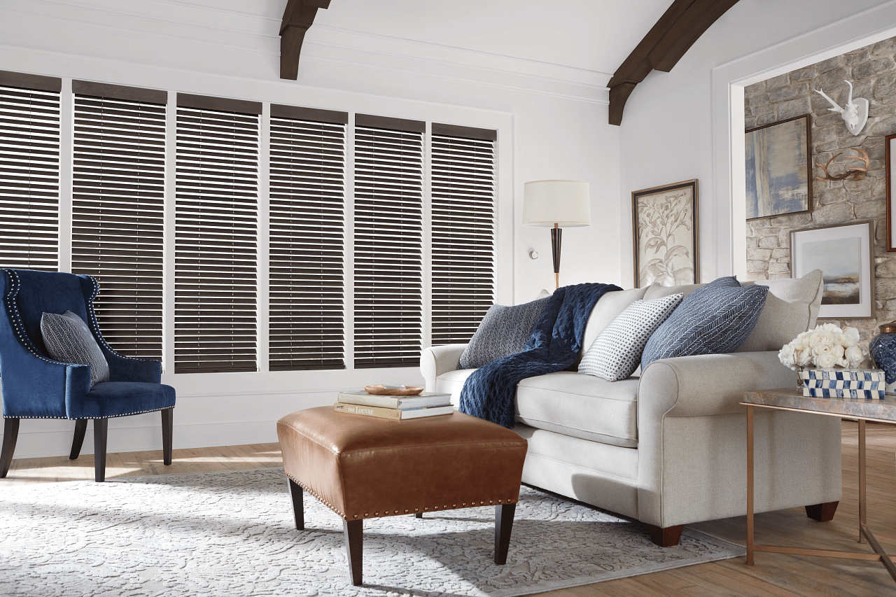 Custom wood blinds filtering in natural light into a beautiful living room