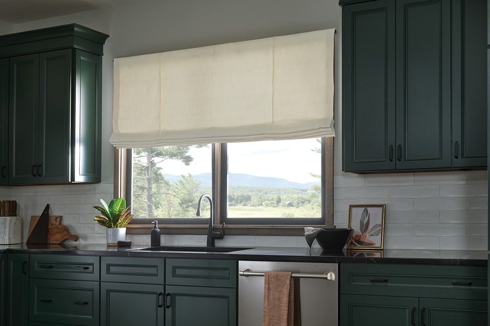 Cozy looking Roman Shades filtering in light to a sleek kitchen.